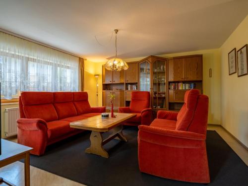 a living room with red furniture and a table and chairs at Holiday Home Rheingau by Interhome in Dittishausen