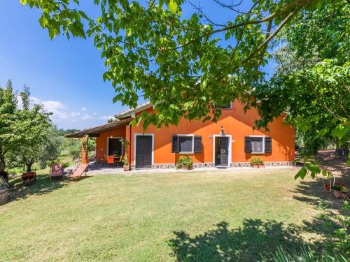 an orange house with a large yard at Holiday Home Podere Cerbaia - SMR100 by Interhome in Santa Maria a Monte