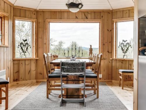 a dining room with a table and chairs and windows at Chalet Fjällnäs - HJD025 by Interhome in Tänndalen