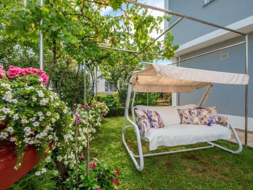 a swing in a garden with flowers at Apartment Markulin by Interhome in Rubeši