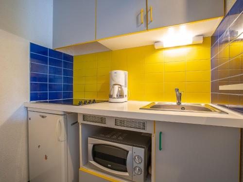 une petite cuisine avec un évier et un micro-ondes dans l'établissement Apartment Tahiti-2 by Interhome, à La Grande Motte