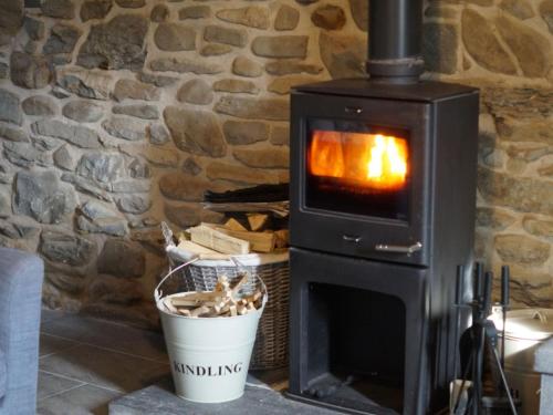 a wood burning stove in a stone wall at Holiday Home Winill by Interhome in Llanddewi-Brefi