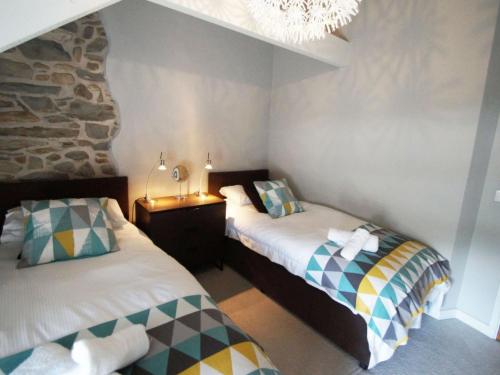 a bedroom with two beds and a chandelier at Holiday Home Winill by Interhome in Llanddewi-Brefi