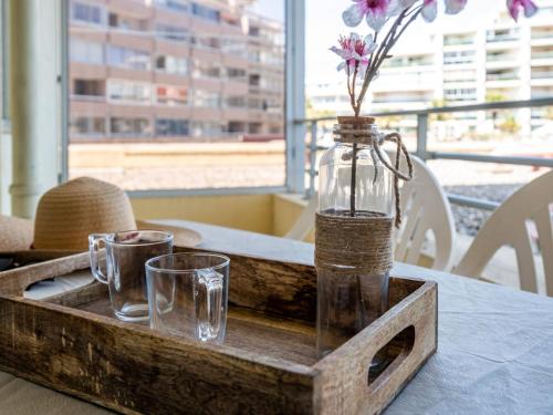 - un plateau en bois avec une bouteille et des verres sur une table dans l'établissement Apartment Le Beach-14 by Interhome, à Canet