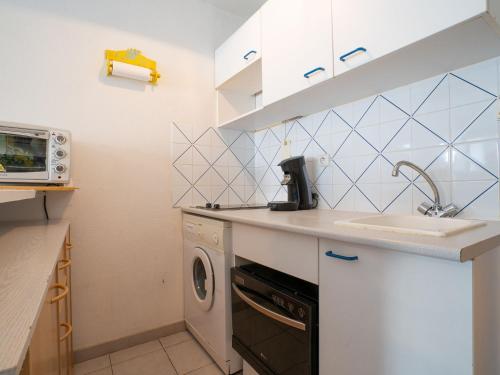 une cuisine avec un évier et une machine à laver dans l'établissement Apartment Le Sunset-Cap Sud-1 by Interhome, au Cap d'Agde