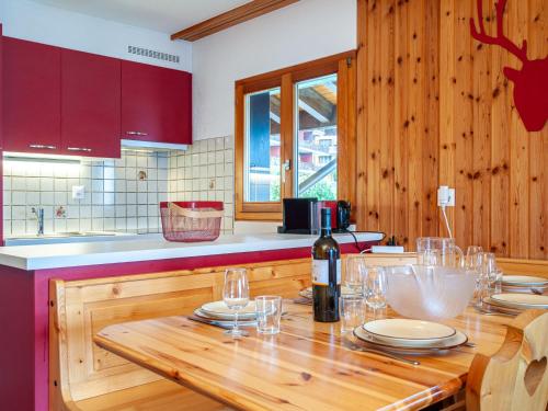 eine Küche mit einem Holztisch mit Weingläsern in der Unterkunft Apartment Les Crêtes 1-3 by Interhome in Veysonnaz