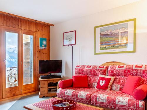 ein Wohnzimmer mit einem Sofa und einem TV in der Unterkunft Apartment Les Crêtes 1-3 by Interhome in Veysonnaz