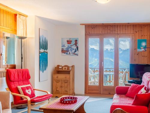 a living room with red chairs and a table at Apartment Les Crêtes 1-3 by Interhome in Veysonnaz