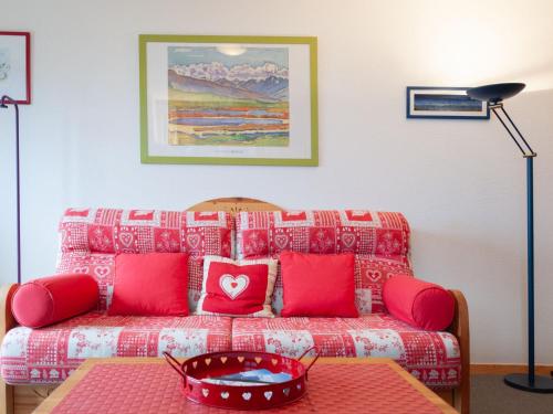 a living room with a couch with red pillows at Apartment Les Crêtes 1-3 by Interhome in Veysonnaz