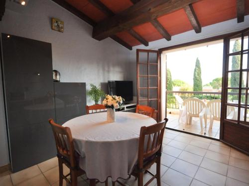 une salle à manger avec une table et un vase de fleurs. dans l'établissement Apartment les Oiseaux-1 by Interhome, à Cavalaire-sur-Mer