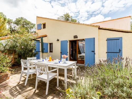 a patio with a table and chairs in front of a house at Holiday Home Hameau de Talaris-3 by Interhome in La Palmyre