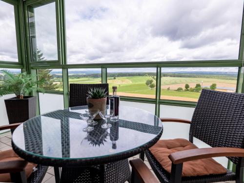 una mesa de cristal y sillas en un balcón con vistas en Apartment F 55 by Interhome en Dittishausen