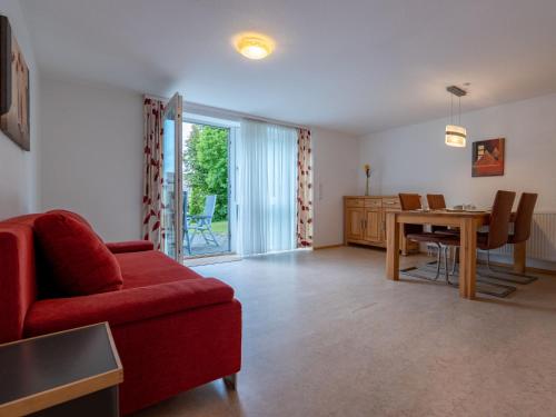 a living room with a red couch and a table at Holiday Home Romeo by Interhome in Dittishausen