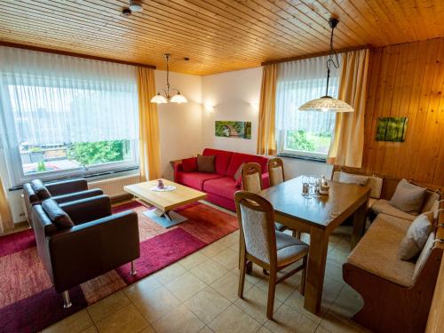 a living room with a red couch and a table at Holiday Home Romeo by Interhome in Dittishausen