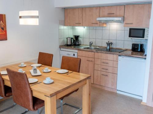 a kitchen with a wooden table with chairs and a sink at Holiday Home Romeo by Interhome in Dittishausen