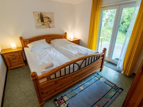 - une chambre avec un grand lit en bois et une fenêtre dans l'établissement Holiday Home Romeo by Interhome, à Dittishausen