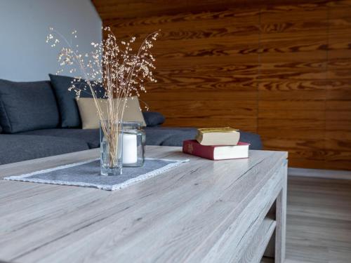 einen Couchtisch aus Holz mit einer Vase und Büchern darauf in der Unterkunft Apartment Hochfirst by Interhome in Dittishausen