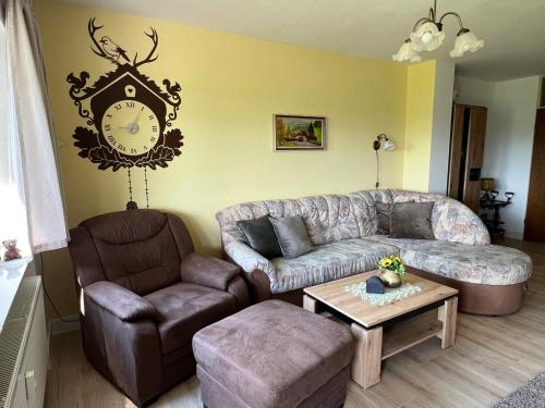 sala de estar con sofá y reloj en la pared en Apartment Schwarzwaldblick-14 by Interhome, en Schonach