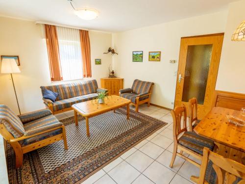 a living room with a couch and a table and chairs at Holiday Home Vergissmeinnicht by Interhome in Dittishausen