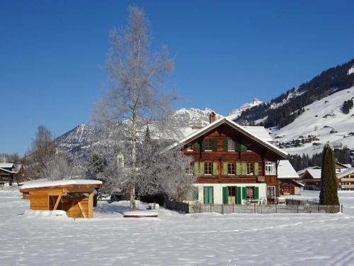 a large wooden house in the snow with snow at Apartment Lischenhaus - Strubel by Interhome in Lenk