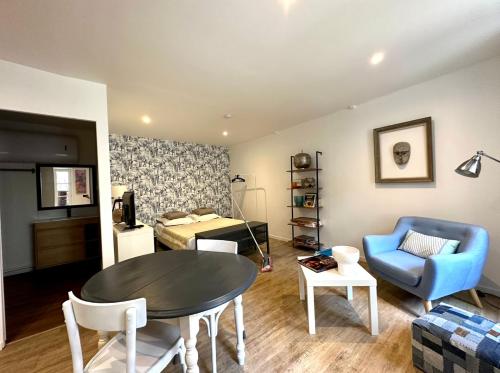 - un salon avec une table et une chaise bleue dans l'établissement C la reserve - St Rose Bleu, à Clermont-Ferrand