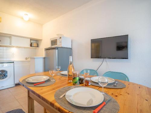 une cuisine avec une table avec des assiettes et des verres à vin dans l'établissement Apartment Port Quiétude-4 by Interhome, à Fréjus