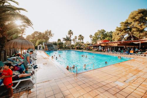 una piscina en un complejo con gente nadando en él en Camping Caledonia en Tamarit