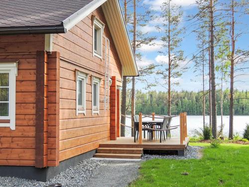 eine Holzhütte mit einem Tisch auf der Veranda in der Unterkunft Holiday Home Nesterin helmi by Interhome in Eno