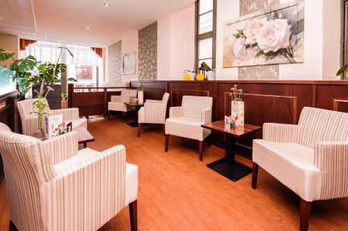 a waiting room with white chairs and a table at Stadthotel Stern in Wismar