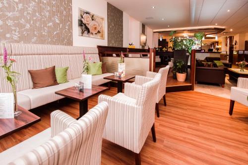 a restaurant with white chairs and tables at Stadthotel Stern in Wismar