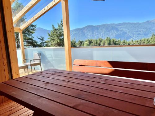 a wooden bench on a balcony with a view of mountains at Holiday Home Sky-Chalet by Interhome in Imst