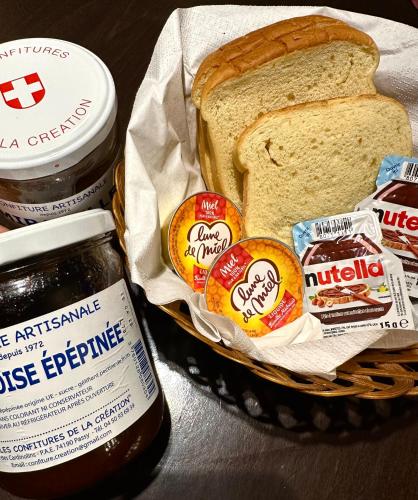 a basket of peanut butter and jelly and a sandwich at Hôtel Du Centre Annemasse in Annemasse