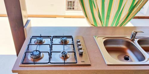 a stove top oven sitting next to a sink at Gurgiolo New Apartment in Trabia