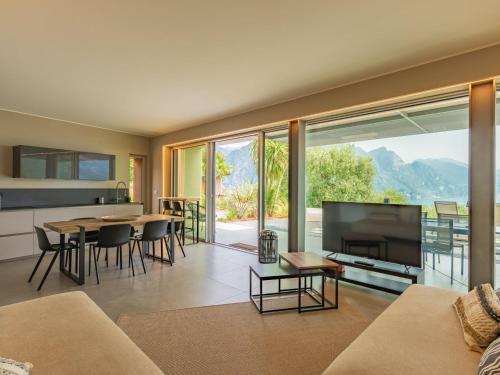 Una sala de estar con un televisor grande y una mesa. en Villa Villa Gau' by Interhome, en Riva di Solto