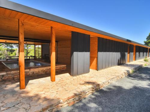 a building with wooden posts and a stone patio at Holiday Home Villa Baraka by Interhome in Božava