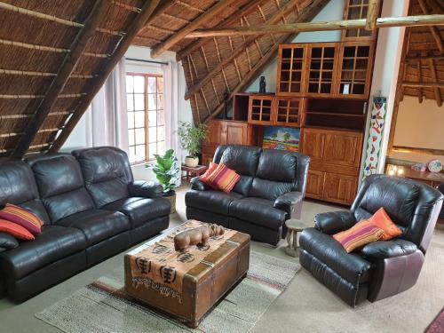 a living room with leather couches and a coffee table at Bronberg Bastion in Tierpoort