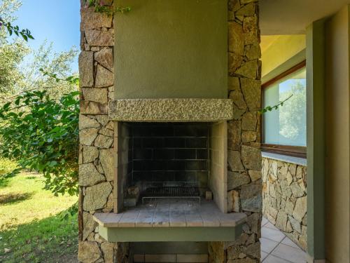 a stone fireplace in the side of a house at Holiday Home Carlo-1 by Interhome in Villasimius