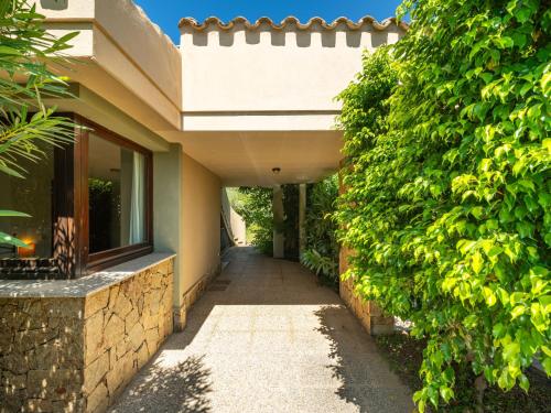 a hallway leading to a house with a hedge at Holiday Home Carlo-1 by Interhome in Villasimius