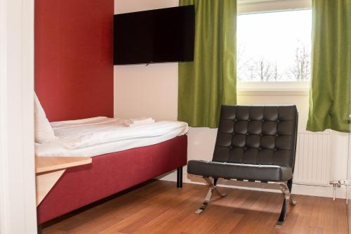 um quarto com uma cama, uma cadeira e uma secretária em Good Morning Jönköping em Jönköping