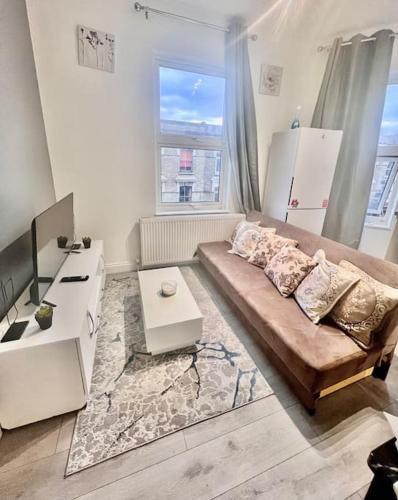 uma sala de estar com um sofá e uma mesa em Flat 3 Battersea Park Rd, 2 bedroom, 1 Bathroom flat em Londres