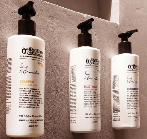 three white shampoo bottles sitting on a wall at Grand Universe Lucca, Autograph Collection in Lucca