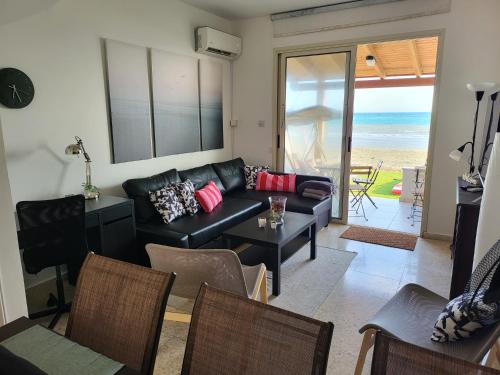 a living room with a couch and a table at Mattis Seafront Beachhouse in Pervolia