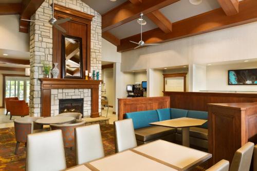 a restaurant with tables and chairs and a fireplace at Residence Inn Joplin in Joplin