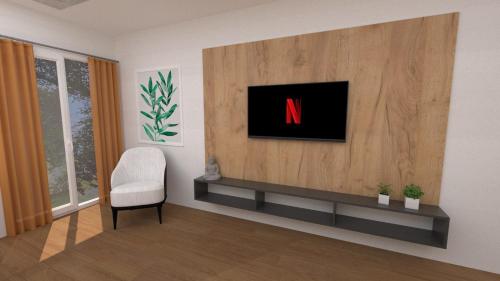 a living room with a tv and a chair at Luxury Apartment IVA III in Skopje