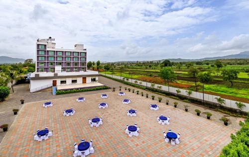 a building with tables and umbrellas in a courtyard at Effotel by Sayaji Sarola in Bhor