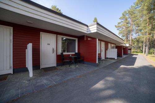 a red building with a table on the side of it at Rantakallan Rinne rivitalohuoneet in Kalajoki