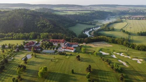 an aerial view of a house in a green field at Darovanský Dvůr - Wellness & Golf Hotel in Břasy