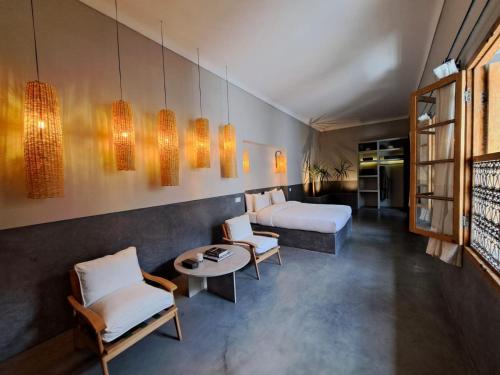 um quarto de hotel com duas camas e uma mesa e cadeiras em Riad no37 em Marraquexe