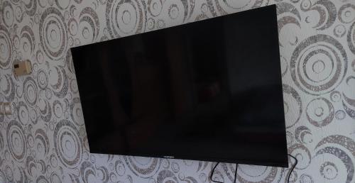 TV de pantalla plana colgada en la pared en Imádni Való Sarokkádas Apartman Salgótarján belvárosában, en Salgótarján
