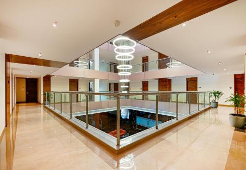 a large lobby with a glass railing and a ceiling at Effotel by Sayaji Sarola in Bhor